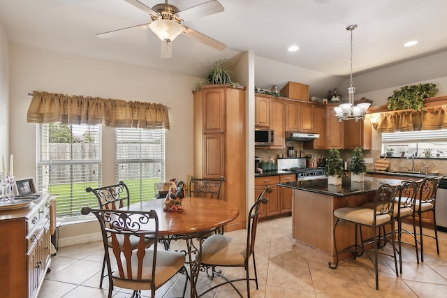 kitchen featuring sink, stainless steel appliances, light tile patterned floors, decorative backsplash, and a kitchen island