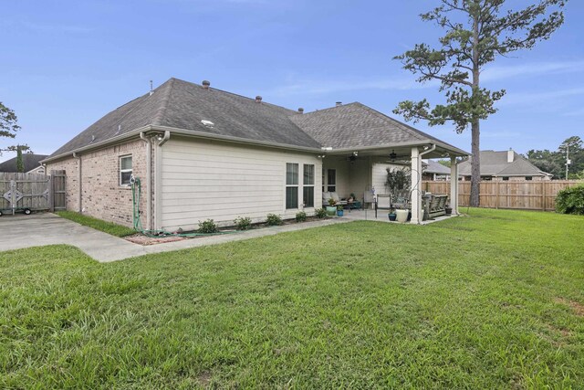 back of house with a patio area, ceiling fan, and a yard