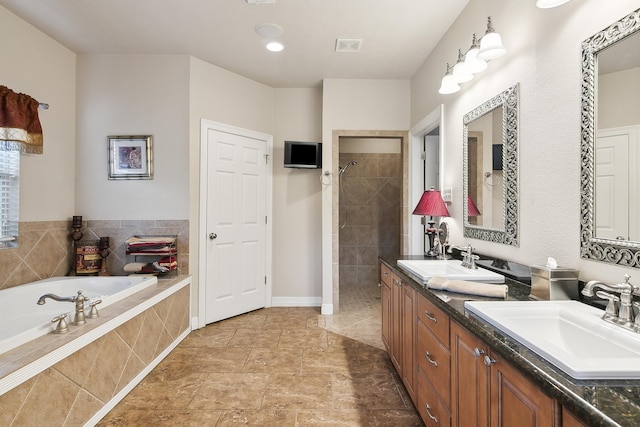 bathroom featuring vanity and independent shower and bath