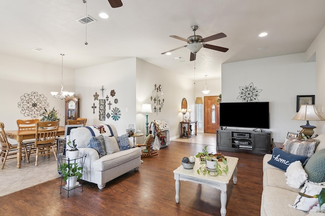 living room with ceiling fan with notable chandelier and dark wood-type flooring