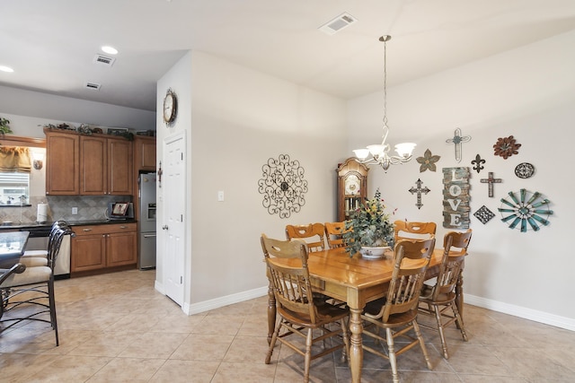 tiled dining area with a chandelier