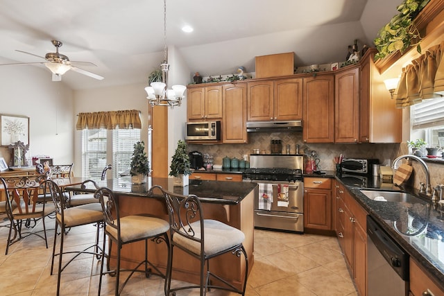 kitchen featuring appliances with stainless steel finishes, ceiling fan with notable chandelier, vaulted ceiling, and sink