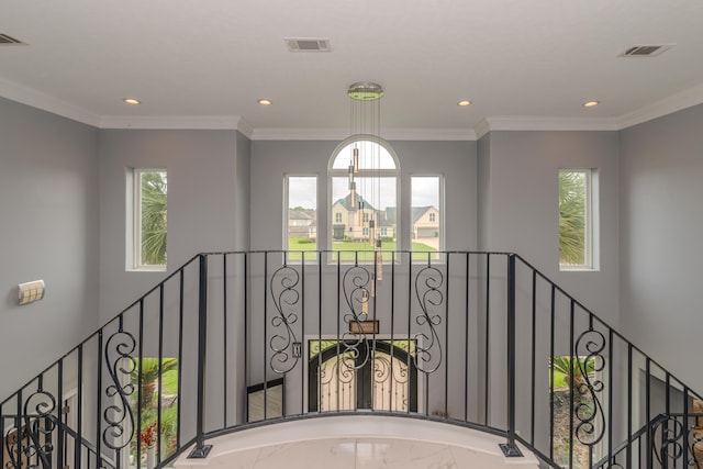 hallway featuring a healthy amount of sunlight, visible vents, and crown molding