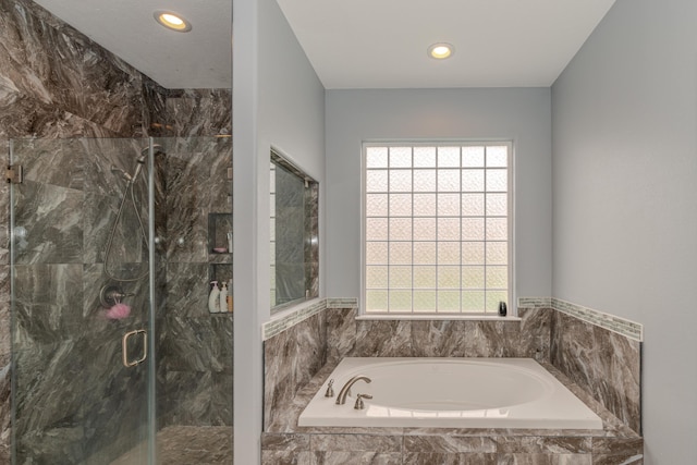 bathroom featuring recessed lighting, a garden tub, a wealth of natural light, and a shower stall