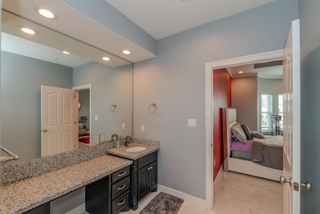 bathroom featuring ensuite bathroom, marble finish floor, recessed lighting, and baseboards