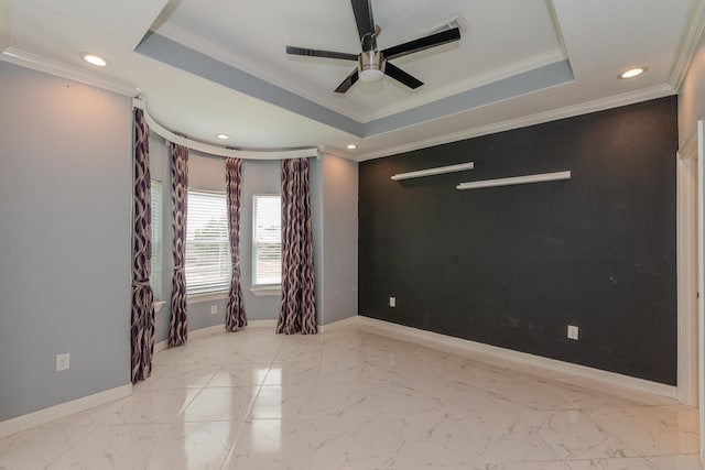 unfurnished room featuring marble finish floor, baseboards, a tray ceiling, and ornamental molding