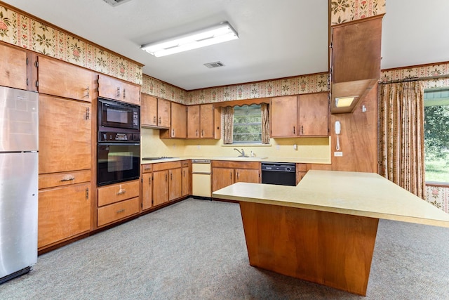 3030 Moore Rd, Beaumont, TX 77713 - kitchen with black appliances, light countertops, plenty of natural light, wallpapered walls, and carpet