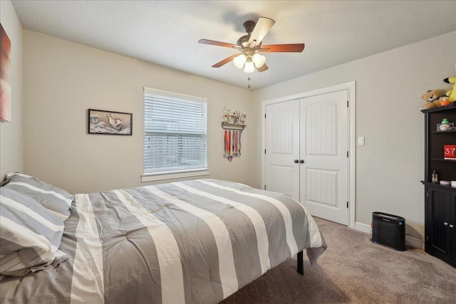 bedroom with ceiling fan, baseboards, a closet, and light colored carpet