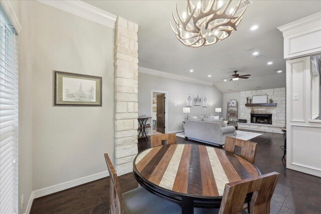 dining area featuring dark wood finished floors, baseboards, crown molding, and a fireplace