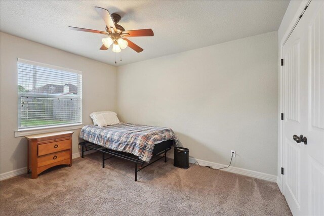 bedroom with light carpet, baseboards, and ceiling fan