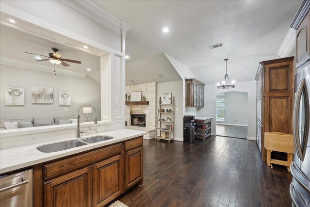 kitchen with ceiling fan with notable chandelier, visible vents, open floor plan, and a sink