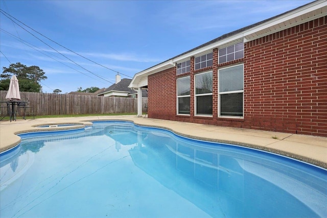 view of pool with a fenced in pool, a patio, an in ground hot tub, and fence