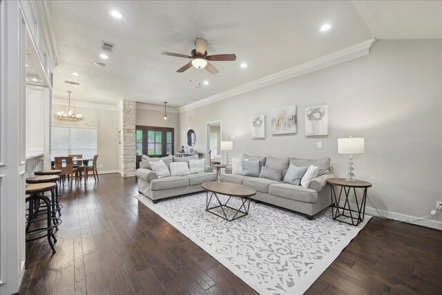 living room featuring ceiling fan with notable chandelier, dark wood-type flooring, and crown molding