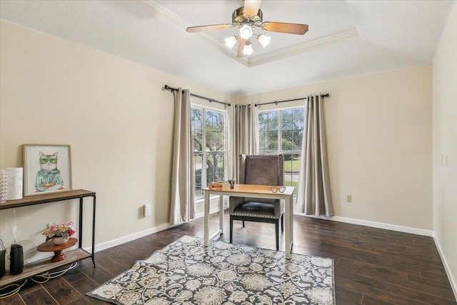 office area with ceiling fan, dark wood-type flooring, ornamental molding, and a tray ceiling