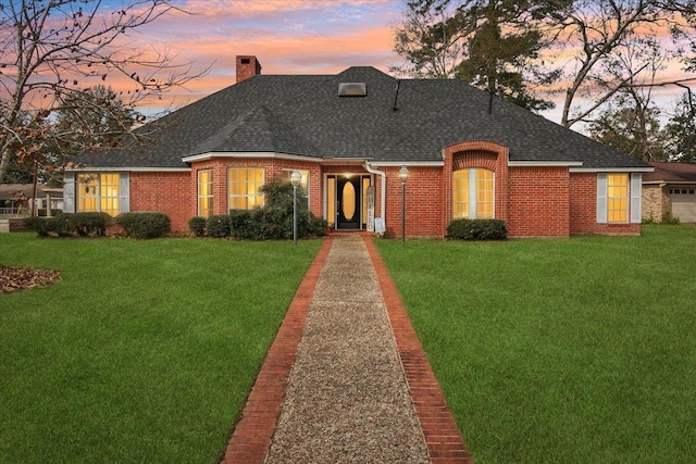 view of front facade with a yard and a garage