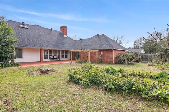 rear view of property featuring a patio area and a lawn