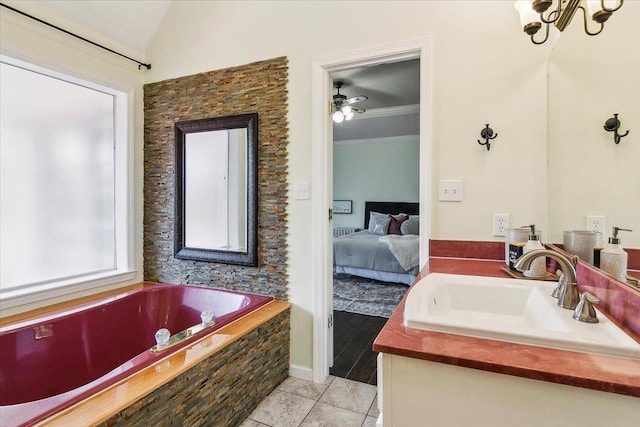 bathroom featuring lofted ceiling, tile patterned floors, ceiling fan, tiled tub, and vanity