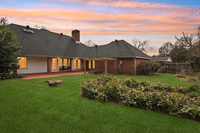 back house at dusk featuring a yard