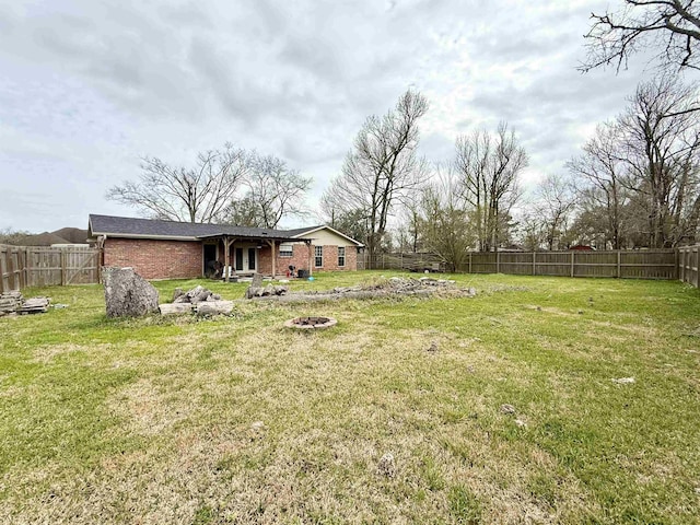 view of yard with a fire pit and a fenced backyard