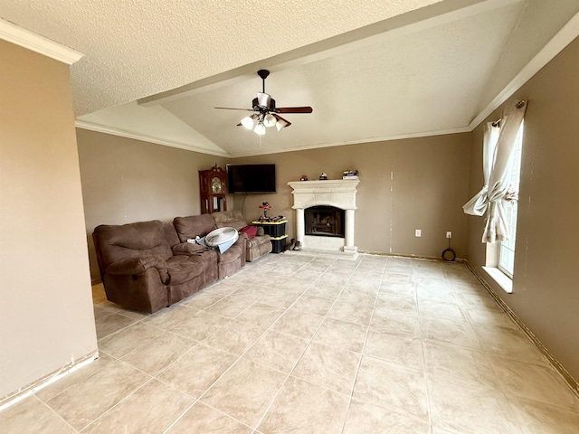 living room featuring a ceiling fan, a fireplace with raised hearth, ornamental molding, vaulted ceiling, and a textured ceiling