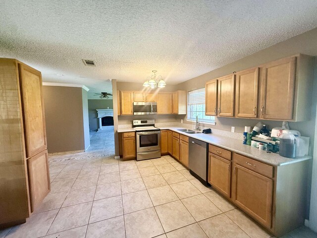 857 Sharp St, Bridge City, TX 77611 - kitchen featuring appliances with stainless steel finishes, light countertops, a textured ceiling, a chandelier, and light tile patterned floors