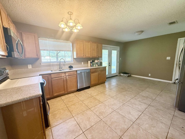 857 Sharp St, Bridge City, TX 77611 - kitchen featuring appliances with stainless steel finishes, a textured ceiling, a chandelier, light countertops, and light tile patterned flooring