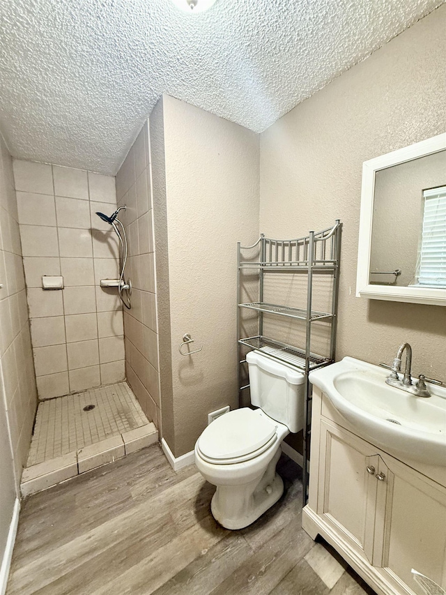 857 Sharp St, Bridge City, TX 77611 - bathroom with a textured ceiling, wood finished floors, a stall shower, vanity, and a textured wall