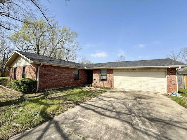 single story home with concrete driveway, brick siding, and a garage