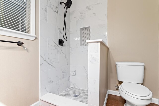 bathroom with toilet and tiled shower