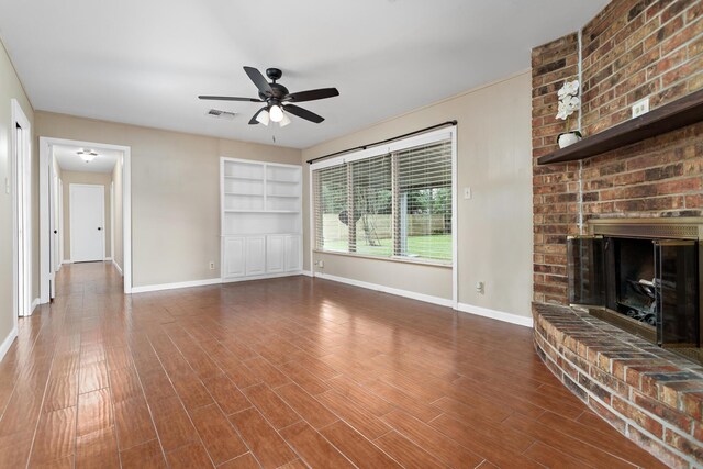 unfurnished living room with dark hardwood / wood-style flooring, ceiling fan, and a fireplace