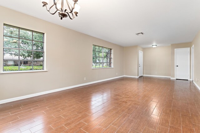 spare room featuring a wealth of natural light and an inviting chandelier