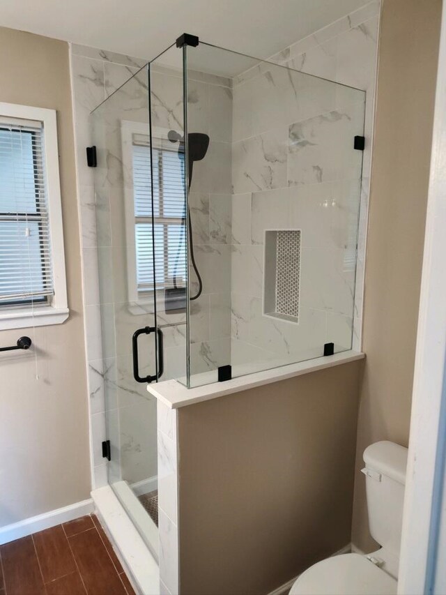 bathroom with an enclosed shower and toilet