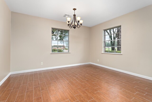 unfurnished room with a chandelier