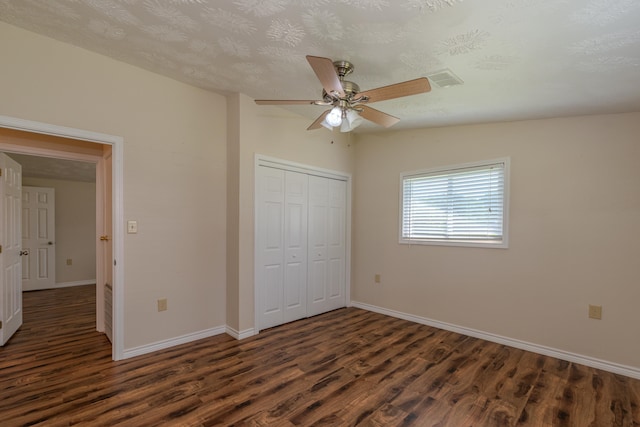 unfurnished bedroom featuring ceiling fan, dark hardwood / wood-style floors, a textured ceiling, and a closet