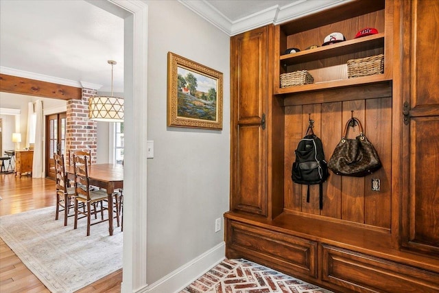 mudroom with ornamental molding and light hardwood / wood-style flooring