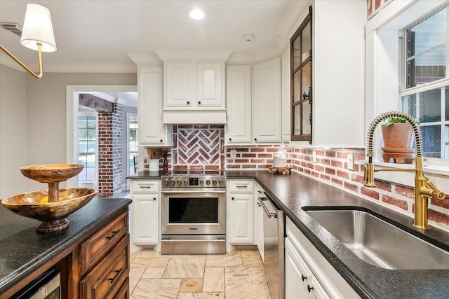 kitchen with stainless steel appliances, white cabinetry, ornamental molding, and sink