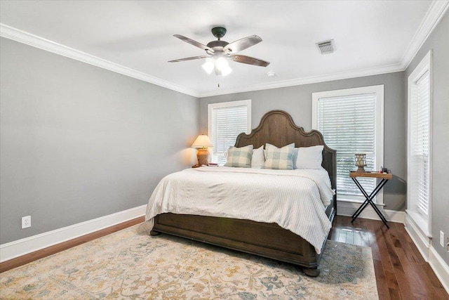 bedroom with ceiling fan, crown molding, and dark wood-type flooring