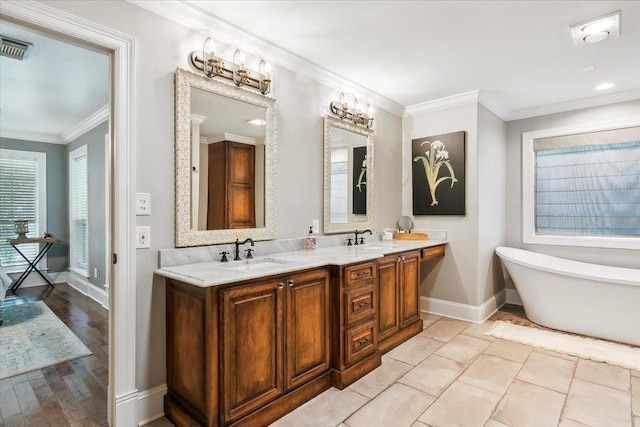 bathroom featuring tile patterned floors, a tub, crown molding, and vanity