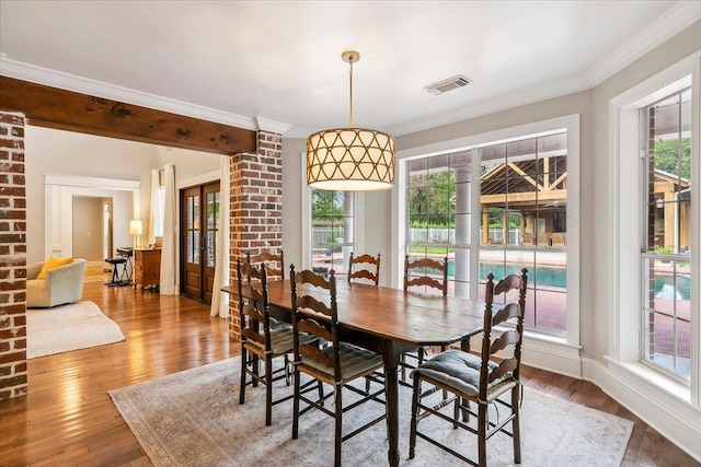 dining area featuring crown molding and hardwood / wood-style flooring