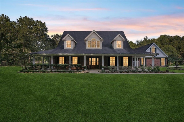 back house at dusk featuring a lawn