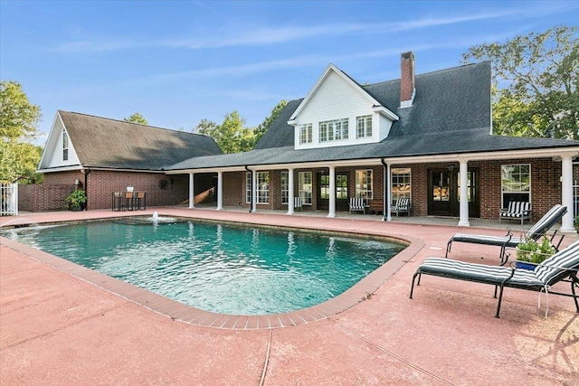 view of swimming pool featuring pool water feature and a patio area