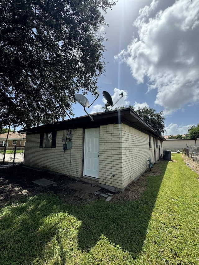 back of house featuring a yard and central AC unit