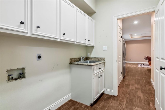 clothes washing area featuring cabinets, washer hookup, electric dryer hookup, sink, and dark hardwood / wood-style floors