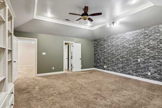 unfurnished bedroom with a raised ceiling, ceiling fan, carpet, and ornamental molding