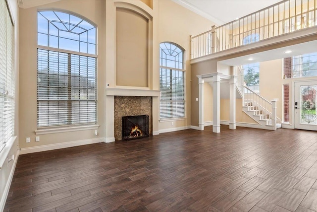 unfurnished living room with a high ceiling and ornamental molding