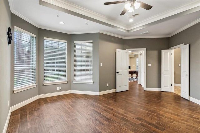 unfurnished bedroom with ceiling fan, a raised ceiling, ornamental molding, and multiple windows