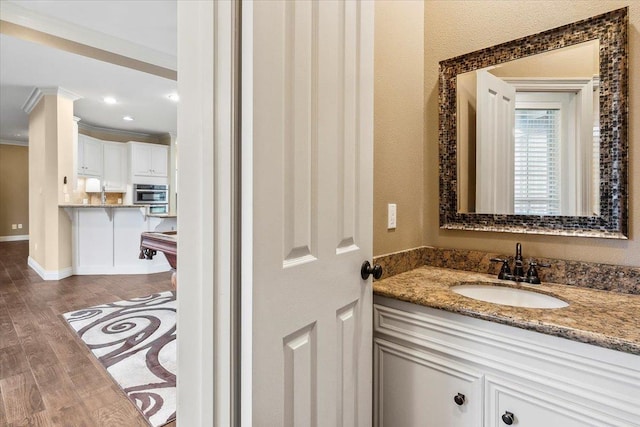 bathroom with vanity, wood-type flooring, ornamental molding, and billiards