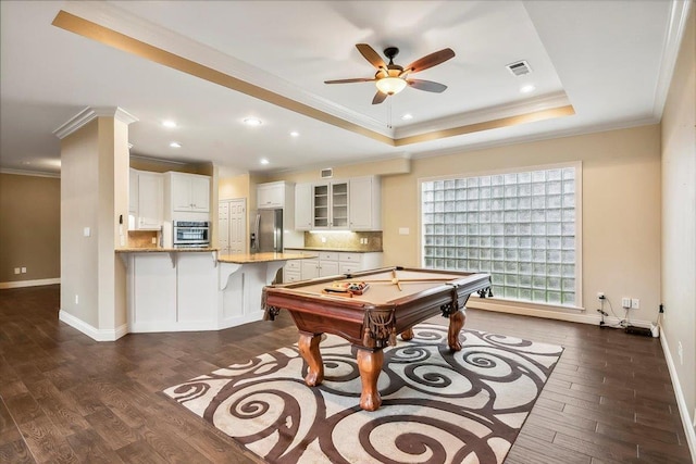 game room with dark hardwood / wood-style floors, crown molding, pool table, and a tray ceiling