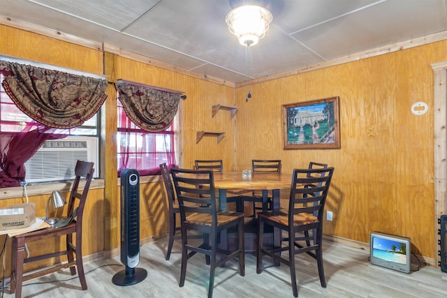 dining space with wood walls, cooling unit, and wood-type flooring