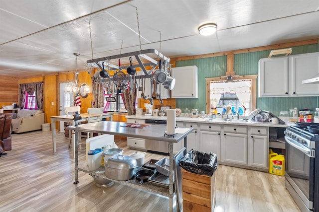 kitchen with stainless steel appliances, sink, light hardwood / wood-style floors, white cabinetry, and hanging light fixtures